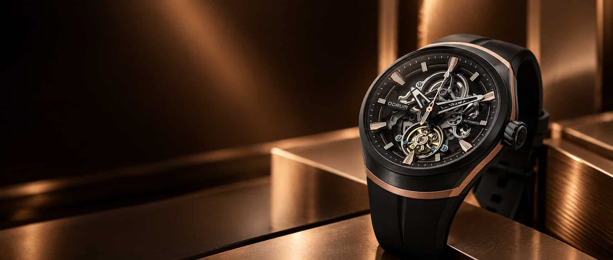 A luxury black and rose gold skeleton watch with a black strap, displayed on a metallic gold surface with a dark, moody background.