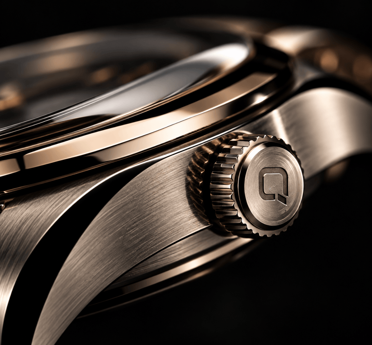 Close-up of a luxury watch featuring a brushed stainless steel case, polished rose gold-toned bezel, and a textured crown knob with a stylized 'Q' logo, set against a dark background.